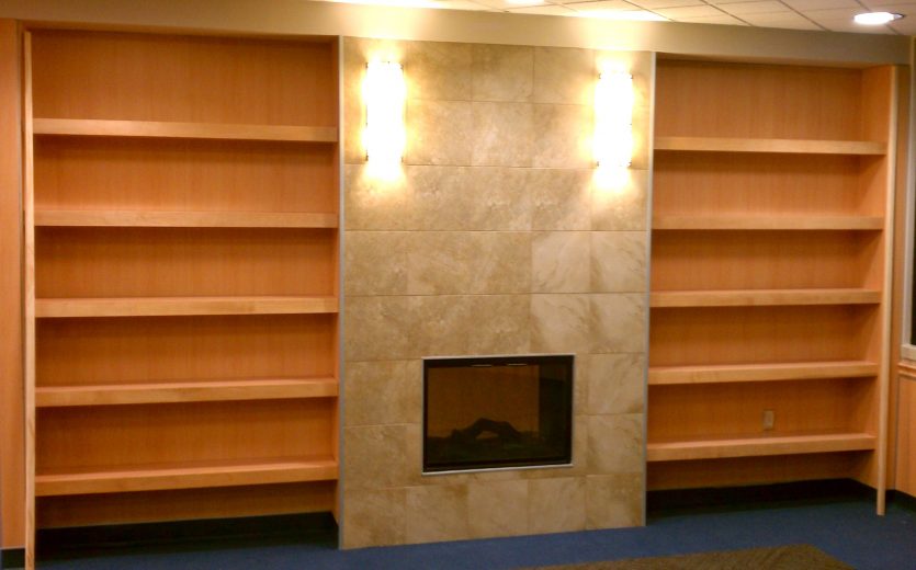 Custom solid wood bookcases surround fireplace